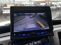 Display screen showing a rearview camera feed of a 2020 Hino 338 truck maneuvering in a parking area with a yellow object visible