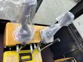 Two joystick controls wrapped in plastic atop a yellow control panel for a 2024 AGT Industrial Yellow H13R Mini Excavator