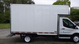 A white 2018 Ford Transit cargo van with a tall box-like rear and a side step platform