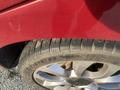 Close-up of a tire on a 2015 Fiat 500L showing tread patterns and a metallic alloy wheel with a circular design