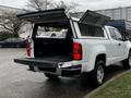 A white 2018 Chevrolet Colorado with the truck bed and lid open showcasing the cargo area