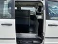 Interior view of a 2011 Dodge Grand Caravan showing the open side door with seating removed and a partition installed