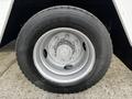Close-up of a silver wheel and tire from a 2006 GMC C5000 showcasing the rim and lug nuts