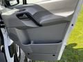 Door panel of a 2017 Mercedes-Benz Sprinter featuring a grey interior with a handle and storage compartment
