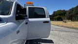 A white 2019 RAM 3500 truck with an open door and an orange light bar on top