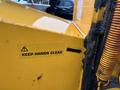 A close-up view of a yellow 1993 Bandit 200+ wood chipper showing a safety sticker that reads keep hands clear with an arrow