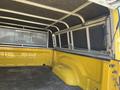 A 2015 RAM 1500 truck bed with a yellow interior and a metal frame canopy equipped with a mesh divider