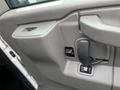 Interior door panel of a 2016 Chevrolet Express featuring a handle a window control button and a small storage compartment