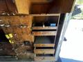A section of a 2009 Morgan Olson Workhorse with wooden drawers and compartments some drawers are open and empty while others contain tools and equipment