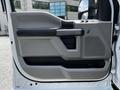 Interior door panel of a 2020 Ford F-350 Super Duty featuring a handle control window switches and textured speaker area
