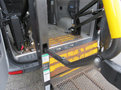 A 2009 Dodge Sprinter Van with a wheelchair ramp partially extended showing yellow and black safety markings and metal grating
