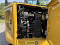 A close-up view of the engine compartment of a 2022 Caterpillar 306 showcasing its detailed components and yellow exterior