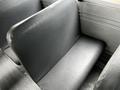 A row of black seats inside a Spartan School Bus, featuring a smooth surface and simple design without any visible wear or damage