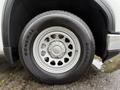 Close-up of a silver wheel of a 2022 GMC Sierra 1500 with a General Grabber tire and distinctive circular spoke design