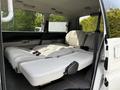 Interior of a 2003 Mitsubishi 7 Passenger Van showing folded rear seats with light gray upholstery and seat belts visible