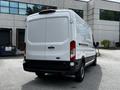 A white 2022 Ford Transit van facing away from the viewer showcasing its rear doors and taillights
