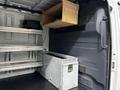A 2020 Mercedes-Benz Sprinter interior featuring metal shelving and a wooden hanging shelf with a stainless steel storage box on the floor
