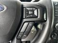 Close-up of the steering wheel controls of a 2017 Ford F-250 featuring volume and call buttons