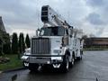 A white 2011 Western Star Trucks 4900 with a raised aerial lift and utility equipment mounted on its bed