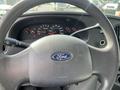 Steering wheel of a 2008 Ford Econoline with a Ford logo and dashboard instruments visible behind it