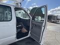 A white 2008 Ford Econoline van with an open front door revealing the interior features and driver's seat