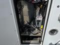 A view of the interior compartment of a 2013 Chevrolet Express with metal flooring and various wiring and electrical components visible