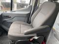 A gray fabric driver's seat from a 2018 Ford Transit with a cushioned back and armrest