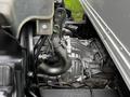 Close-up of a 2012 Mitsubishi Fuso FE engine showcasing various components including the intake manifold and connecting hoses