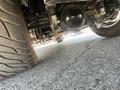 A 1962 Ford F-100 viewed from underneath showcasing the rear axle and suspension components along with a large tire
