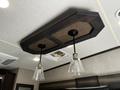 A ceiling light fixture with a dark wooden base and two glass pendant lights hanging from it