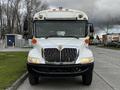 Front view of a 2013 International 4200 bus with a white body and prominent grille featuring the International logo