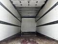 Interior view of a 2019 Hino 195 truck with a spacious empty cargo area featuring metal strips along the walls and a flat floor