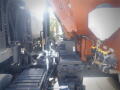 A 2016 International WorkStar 7500 truck with visible hydraulic components and an orange hopper attached to the rear