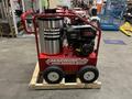 A red and silver 2024 Magnum 4000 Hot Water Pressure Washer on a wooden pallet featuring a gas engine and large wheels for mobility