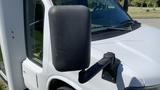 A black side mirror is attached to a white 2011 Chevrolet Express van with a visible door and front window