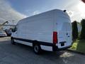 A 2022 Mercedes-Benz Sprinter van shown from the side with a white exterior and black accents featuring a high roof and a spacious cargo area