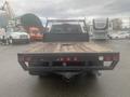 A 2015 Chevrolet Silverado 3500HD with a flatbed design featuring wooden planks and multiple red and white taillights