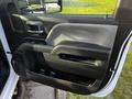 A close-up view of the interior door panel of a 2017 Chevrolet Silverado 3500HD featuring a handle armrest and control buttons