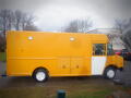 A yellow 2008 Freightliner MT45 Chassis with a white door featuring side compartments and a boxy design typical of food trucks or delivery vehicles