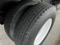 Close-up of two large truck tires from a 2022 Isuzu NPR showcasing tread patterns and rims without any visible damage or wear