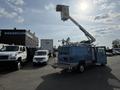 A blue 2010 Ford Econoline van with an elevated aerial work platform attached to the roof is parked with the side door open