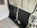 Interior view of a 2012 GMC Savana showing the cargo area with black paneling on the sides and a bare floor showing signs of use