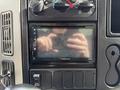 A modern dashboard display with controls for an International TerraStar featuring a touchscreen and several buttons including an audio system display and climate controls