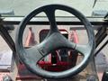 A close-up view of the steering wheel of a 2014 Toro Groundmaster 5910 with visible controls and a red interior surrounding it