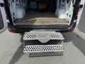 A 2016 Mercedes-Benz Sprinter with an open rear door revealing a sturdy metal step and a wooden floor inside the cargo area