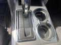 The center console of a 2014 Ford F-150 showing the gear shift with PRND21 markings and two cup holders on either side