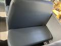 A seat from a 2007 Blue Bird Vision bus with a smooth dark blue vinyl surface and a cushioned backrest