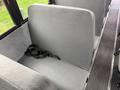 Interior seating of a 2022 Freightliner B2 bus featuring a gray textured upholstery and a seat belt in black laying on the seat