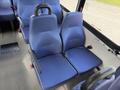 Two blue fabric seats with armrests arranged in a row inside a vehicle