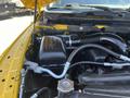 A close-up view of the engine compartment of a 2015 RAM 1500 featuring a black air intake and various connected hoses and components